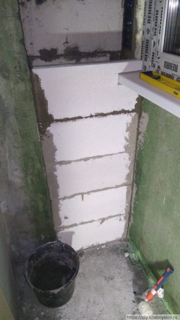 Установленный газоблок с канавкой для обхода подоконника при возведение перегородки на балконе дома П-44Т