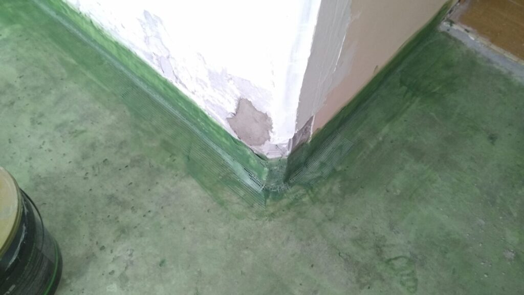 Устранение повреждений в углу стенки сантехкабины в процессе гидроизоляции